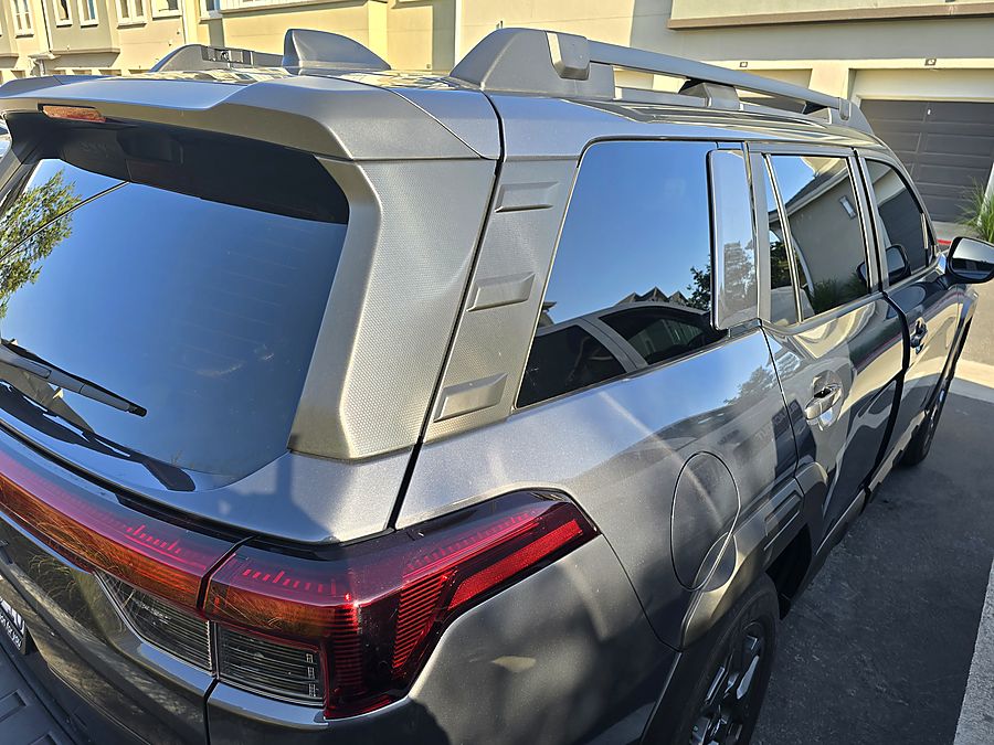Subaru Outback — rear hatch and quarter glass, film wrapped to the edge with the defroster lines intact